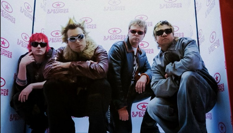 5sos posing inside a box wearing their "Everyone's a Star" album outfits.